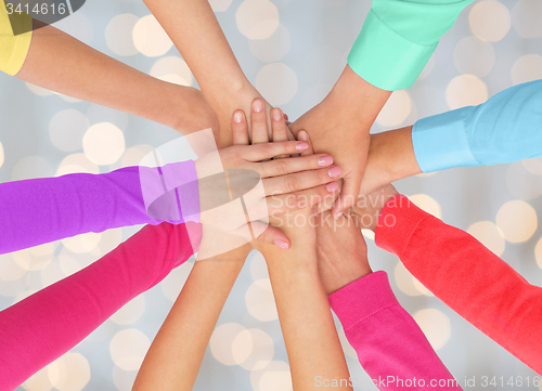 Image of close up of women hands on top in rainbow clothes