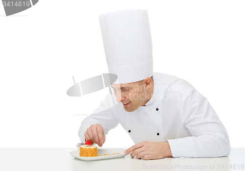 Image of happy male chef cook decorating dessert