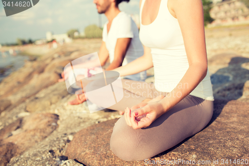 Image of close up of couple making yoga exercises outdoors