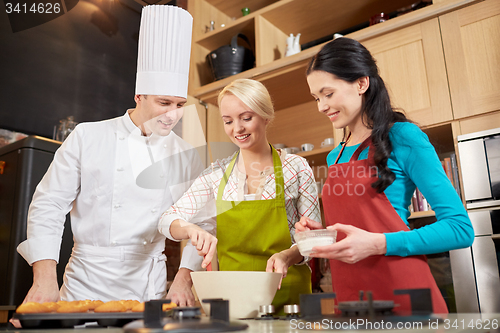 Image of happy women and chef cook baking in kitchen