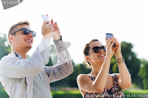 Image of smiling friends with smartphone taking picture