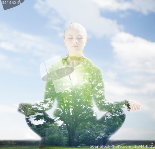 Image of happy young woman doing yoga outdoors