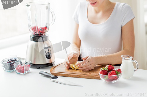 Image of close up of woman with blender chopping banana