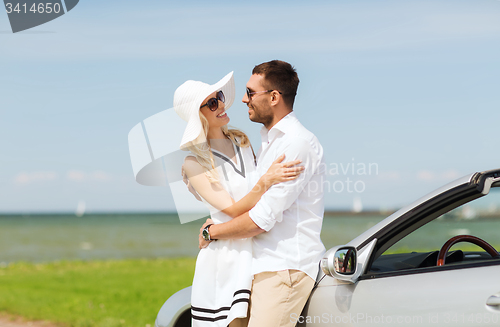 Image of happy man and woman hugging near car at sea