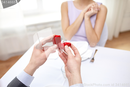 Image of excited young woman and boyfriend giving her ring