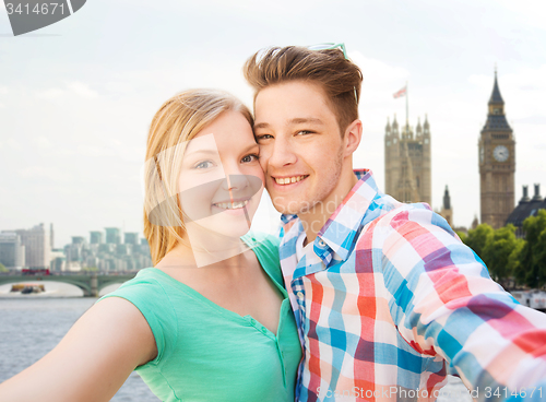 Image of happy couple taking selfie over london city