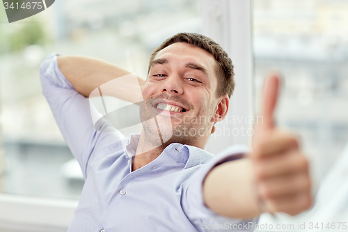 Image of smiling man showing thumbs up at home or office