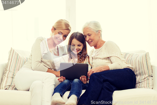 Image of smiling family with tablet pc at home