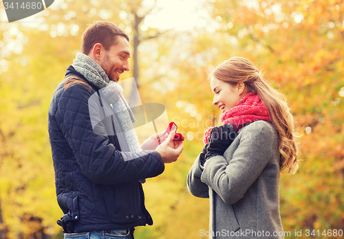 Image of smiling couple with engagement ring in gift box