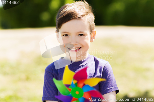 Image of happy little boy with colorful pinwheel at summer