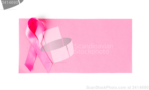 Image of close up of pink cancer awareness ribbon on paper