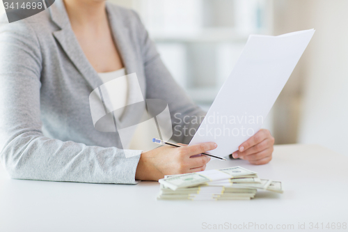 Image of close up of female hands with money and tax report