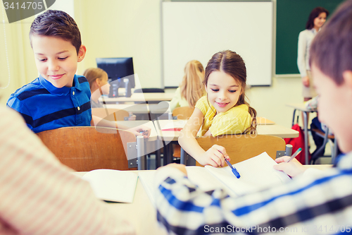 Image of group of school kids writing test in classroom