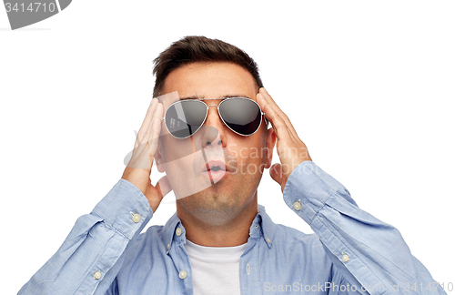 Image of face of scared man in shirt and sunglasses