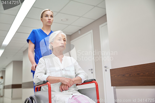 Image of nurse with senior woman in wheelchair at hospital