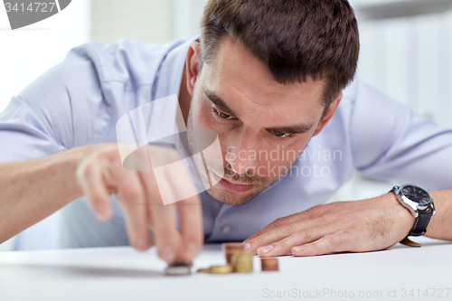 Image of businessman with coins at office