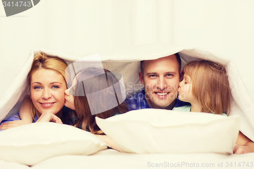 Image of two little girls kissing their parents on cheek