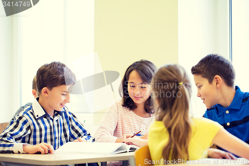 Image of group of school kids writing test in classroom