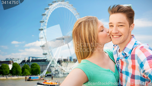 Image of happy couple taking selfie over london