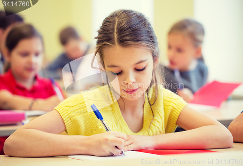 Image of group of school kids writing test in classroom