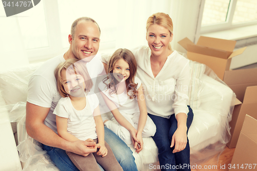 Image of smiling parents and two little girls at new home