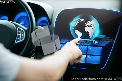 Image of man hand pointing finger to car monitor with globe