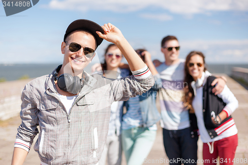 Image of teenage boy with sunglasses and friends outside