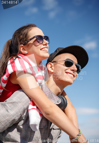 Image of smiling teenagers in sunglasses having fun outside