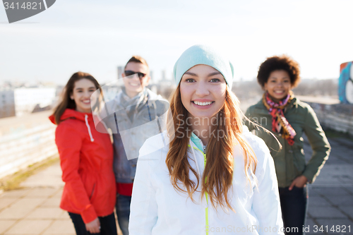 Image of group of happy teenage friends on city street