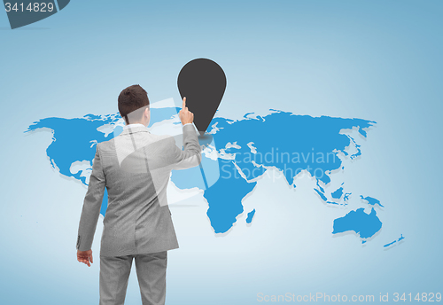 Image of businessman pointing finger to mark on world map