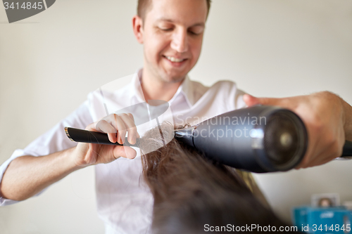 Image of  close up of stylist making hairdo at salon