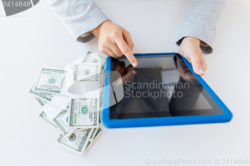 Image of close up of woman hands with tablet pc and money