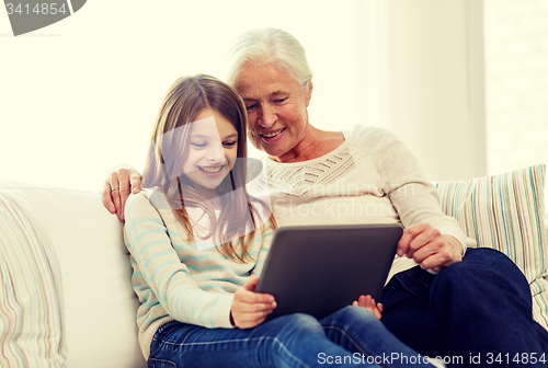 Image of smiling family with tablet pc at home