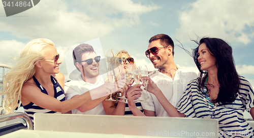 Image of smiling friends with glasses of champagne on yacht