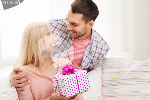 Image of happy man giving woman gift box at home