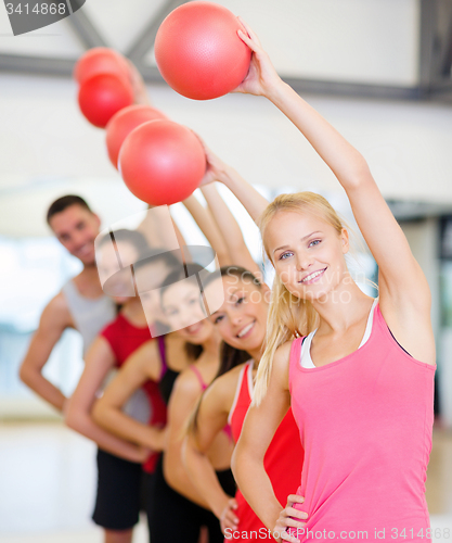 Image of group of smiling people working out with ball