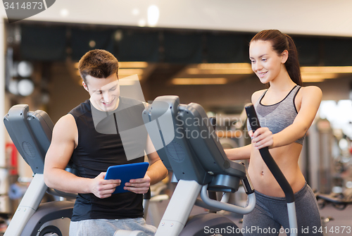 Image of woman with trainer exercising on stepper in gym