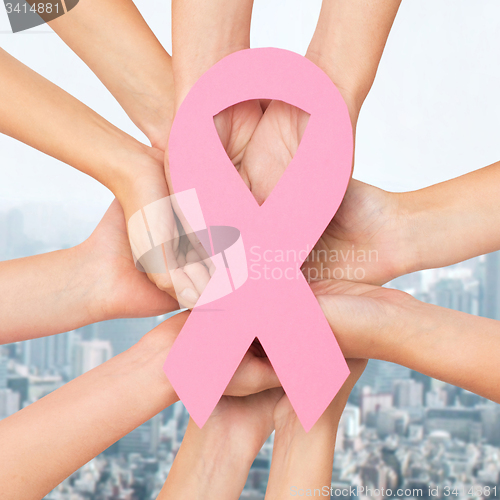 Image of close up of hands with cancer awareness symbol