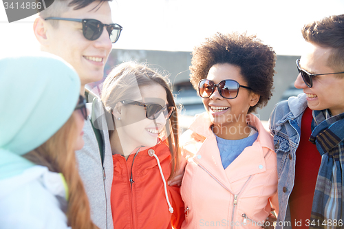 Image of happy teenage friends in shades talking on street