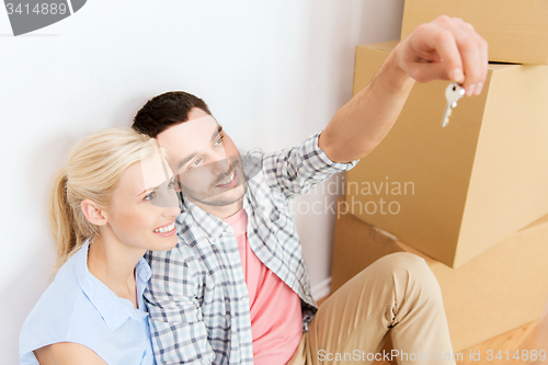 Image of couple with key and boxes moving to new home