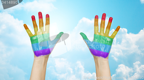 Image of palms of human hands painted in rainbow colors