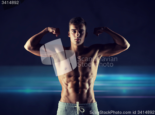 Image of young man showing biceps and muscles