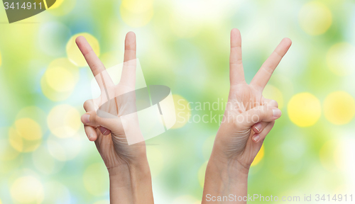 Image of woman hands showing victory or peace sign