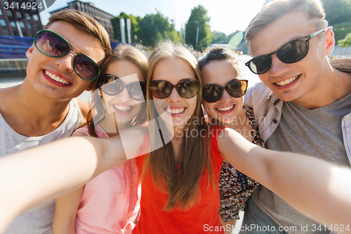 Image of smiling friends taking selfie