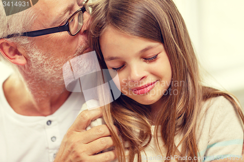 Image of grandfather with crying granddaughter at home