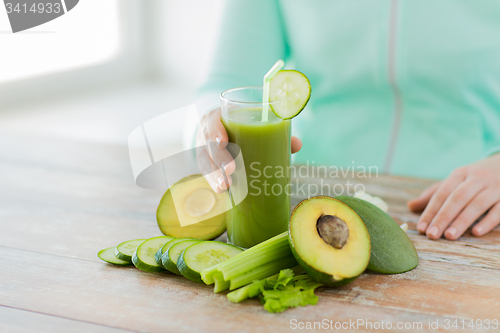 Image of close up of woman hands with juice and vegetables