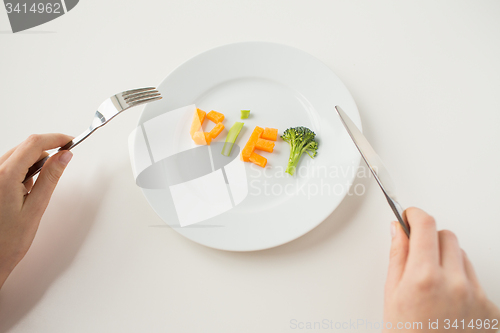 Image of close up of woman hands eating vegetables