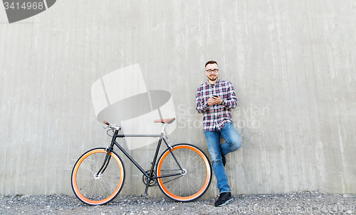 Image of hipster man in earphones with smartphone and bike