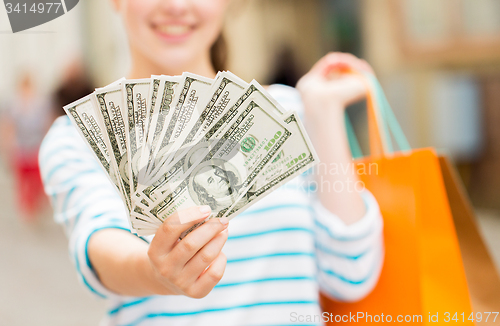 Image of close up of woman with shopping bags and money