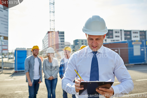 Image of happy builders and architect at construction site